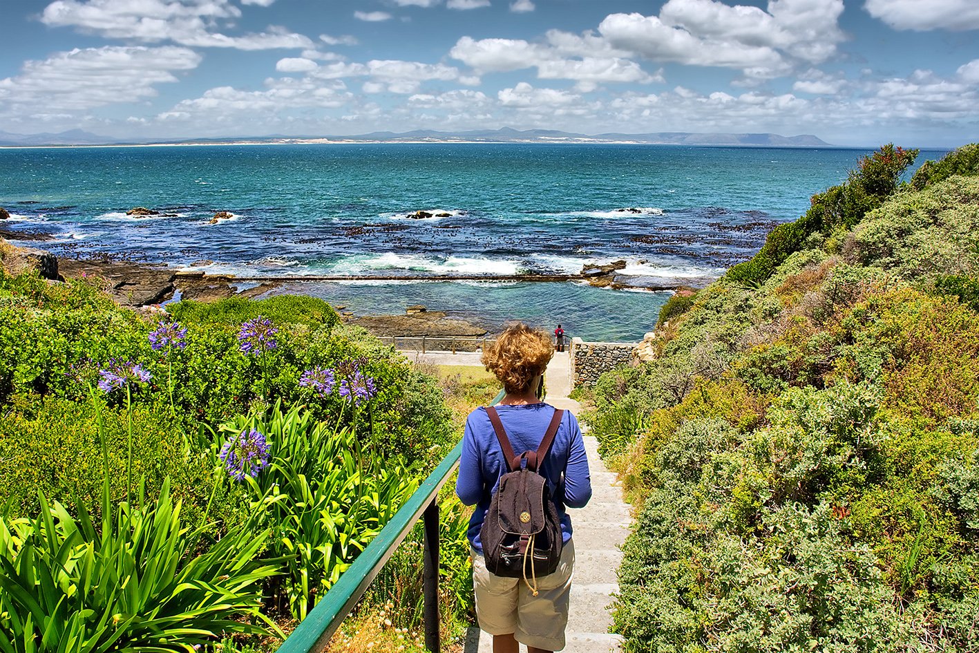 Woman looks at sea from awesome garden. Shot in Hermanus, Walker Bay, Western Cape, South Africa.